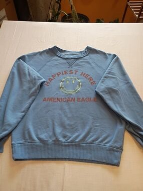 American Eagle Outfitters Light Blue Crewneck with Yellow Smiley Graphic